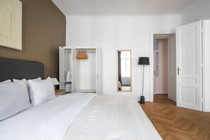 A hotel room with a large bed, a wardrobe, a mirror, and a floor lamp. - Blueground | Landstraße, washer/dryer, nr Prater (Vienna)