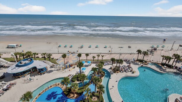 A resort with a large pool, beach access, and a view of the ocean. - Nana's Sweet Retreat at Ocean Walk (Daytona Beach)