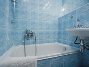 Un bany amb banyera, plat de dutxa i un lavabo.