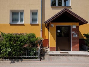 Un edifici amb una porta marró, una finestra petita i un rètol que diu '9B'.