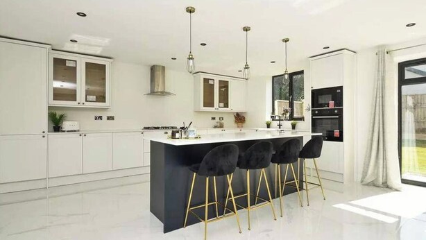 A modern kitchen with white cabinets, a black island with bar stools, and pendant lighting. - 8 Bedroom House Sleeps 20 - Private Garden (Wolverhampton)