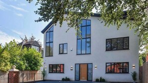 A modern two-story building with large windows and a central entrance. - 8 Bedroom House Sleeps 20 - Private Garden (Wolverhampton)
