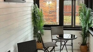 A covered patio area with a table and chairs, potted plants, and string lights. - Relaxing 3-bedroom house in terrific Cincinnati with Firepit and Patio (Cincinnati)
