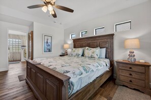 A bedroom with a wooden bed, two bedside tables, a ceiling fan, and a window with a view. - Sunset Retreat with heated pool (Rotonda West)