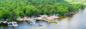 A lakeside cabin with a dock, surrounded by dense forest.