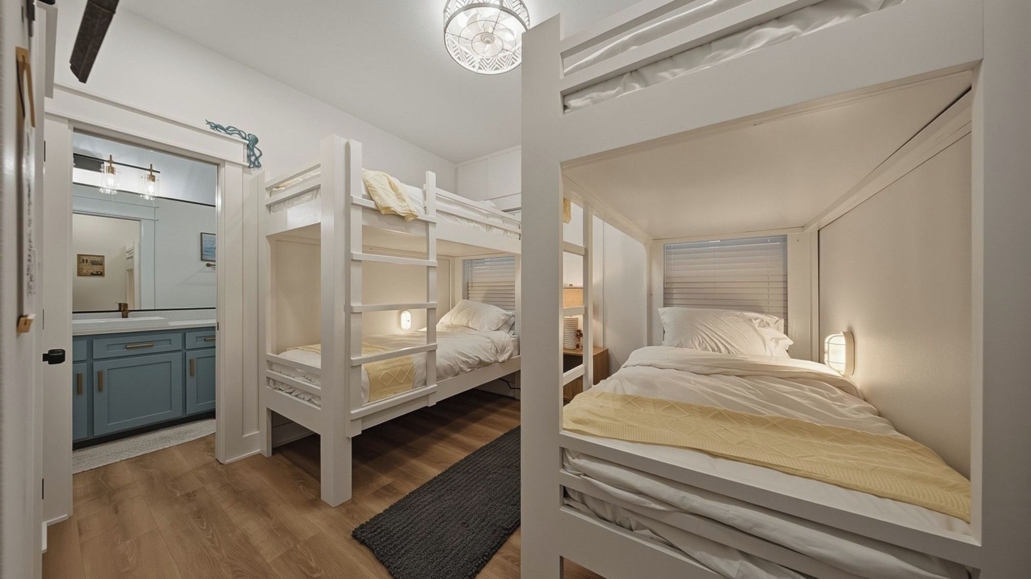 Una habitació amb lliteres, un bany amb mirall i una cuineta.
