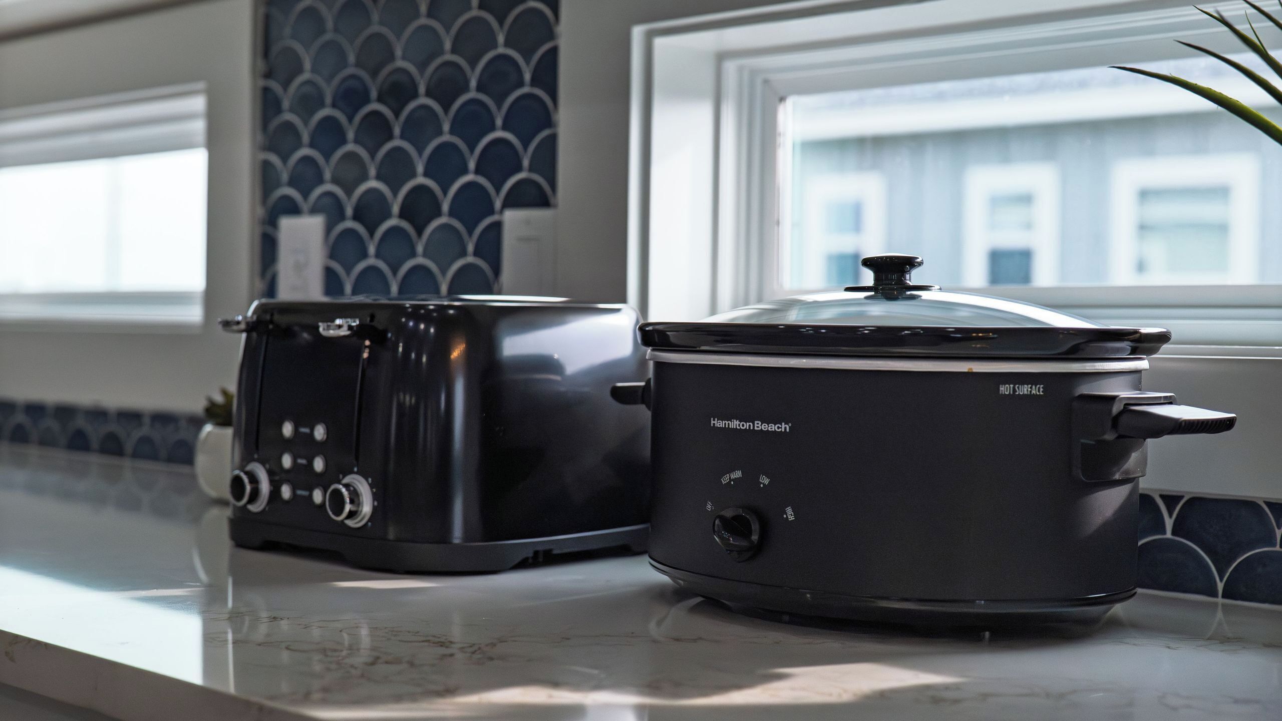 Et køkken med en Hamilton Beach slow cooker og en brødrister på disken.