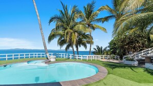 A swimming pool with a white fence, palm trees, and a view of the ocean. - With sea views / View Next to the Oxxo viewpoint (Mismaloya Aguacate)