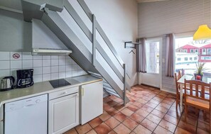 A compact kitchen with a Bosch dishwasher, a coffee maker, and a window overlooking a red building. - Cozy home in Krokkleiva with sauna (Krokkleiva)