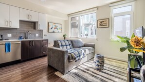 Un appartement moderne doté d’une cuisine, d’un espace de vie et de grandes fenêtres.