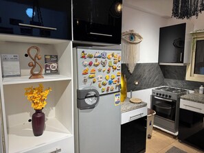 Eine moderne Küche mit einem Edelstahl-Kühlschrank, einem Gasherd und einer Mikrowelle.