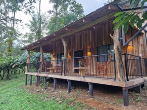 A wooden cabin with a balcony, surrounded by trees. - Finca Amistad Cacao Lodge (Bijagua)