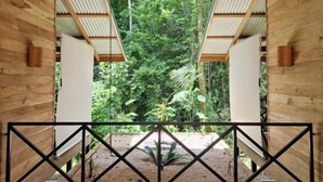 A modern interior with a wooden floor and a view of lush greenery outside. - Finca Amistad Cacao Lodge (Bijagua)