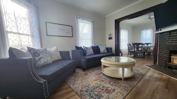 Un salon avec un canapé bleu foncé, une table basse ronde et un tapis à motifs.