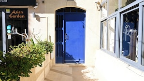 Ein Gebäude mit einer blauen Tür, einem Schild mit der Aufschrift 'Asian Garden' und einem Schild mit der Aufschrift 'Sharon'.