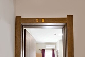 Una puerta con marco de madera y un cartel que indica la habitación 5B.