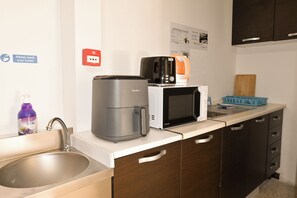 A kitchenette with a coffee maker, microwave, and a sink. - Sea Breeze Bay Guesthouse - B4, Saint Paul's Bay, Malta (Saint Paul's Bay)
