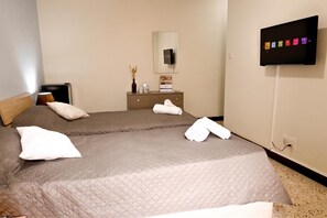 A hotel room with two beds, a flat-screen TV, a dresser, and a mirror. - Sunny Ensuite by the Sea - B4, Saint Paul's Bay, Malta (Saint Paul's Bay)