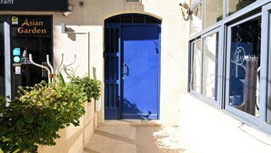 Ein Gebäude mit einer blauen Tür, einem Schild mit der Aufschrift 'Asian Garden' und einem Schild mit der Aufschrift 'Sharon'.