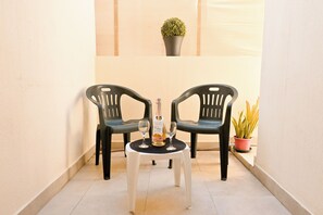 A small outdoor seating area with two chairs and a table, a bottle, and two glasses. - Sea Breeze Bay Guesthouse - A4, Saint Paul's Bay, Malta (Saint Paul's Bay)
