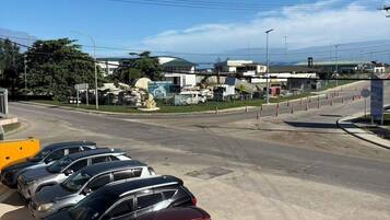 A parking lot with several cars, a clear sky, and buildings in the background.