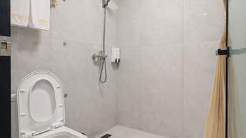 Un baño moderno con inodoro, ducha y mampara de vidrio.