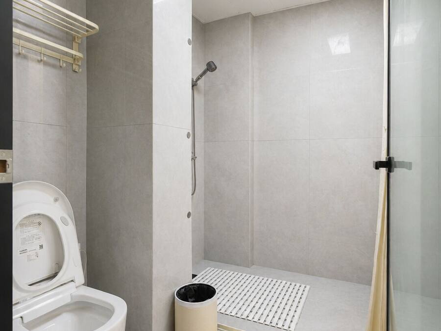 Ein modernes Badezimmer mit Toilette, Dusche und einer Glasabtrennung.