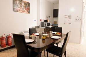 A conference room with a long table, chairs, a coffee machine, and a fire extinguisher. - Sea Breeze Bay Guesthouse - A1, Saint Paul's Bay, Malta (Saint Paul's Bay)
