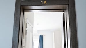 A doorway with a number sign '1A' above it, leading to a room with a visible shower curtain. - Sunny Ensuite by the Sea - A1, Saint Paul's Bay, Malta (Saint Paul's Bay)