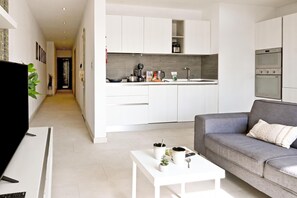 A modern kitchen with white cabinetry, a built-in oven, and a countertop with various appliances. - A Sunny Seaview In Central Sliema, Sliema, Malta (Sliema)