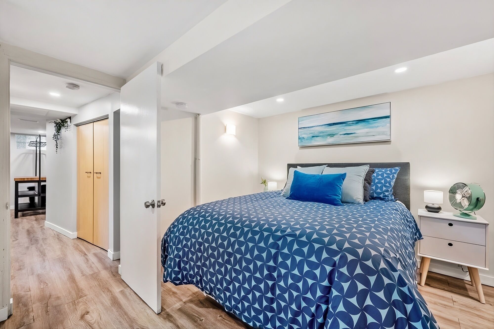 Une chambre à coucher avec un lit, une table de chevet et une commode.