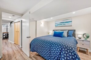 A bedroom with a bed, bedside table, and a nightstand.