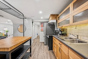 Una cocina moderna con una mesa de madera, un refrigerador y un lavaplatos.