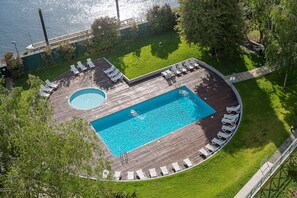 An aerial view of a pool area with a rectangular pool, a circular hot tub, and multiple lounge chairs arranged around the pool. - GuestReady - Elegant riverside retreat (Valbom)