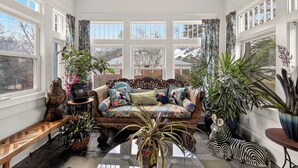 A cozy room with a sofa, potted plants, and a zebra statue. - Comfort and Space with convenience (Atlanta)