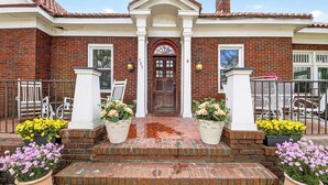 A brick building with a central entrance, white columns, and a red-tiled roof. - Comfort and Space with convenience (Atlanta)