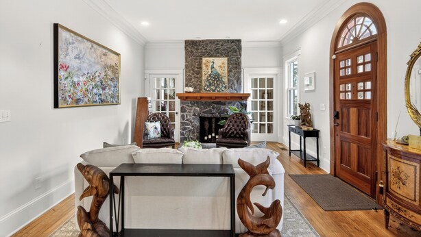A spacious living room with a stone fireplace, two leather armchairs, a white sofa, and a wooden coffee table. - Comfort and Space with convenience (Atlanta)