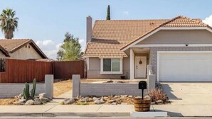 Une maison de plain-pied avec un toit en tuiles, un garage à l’avant et une boîte aux lettres.
