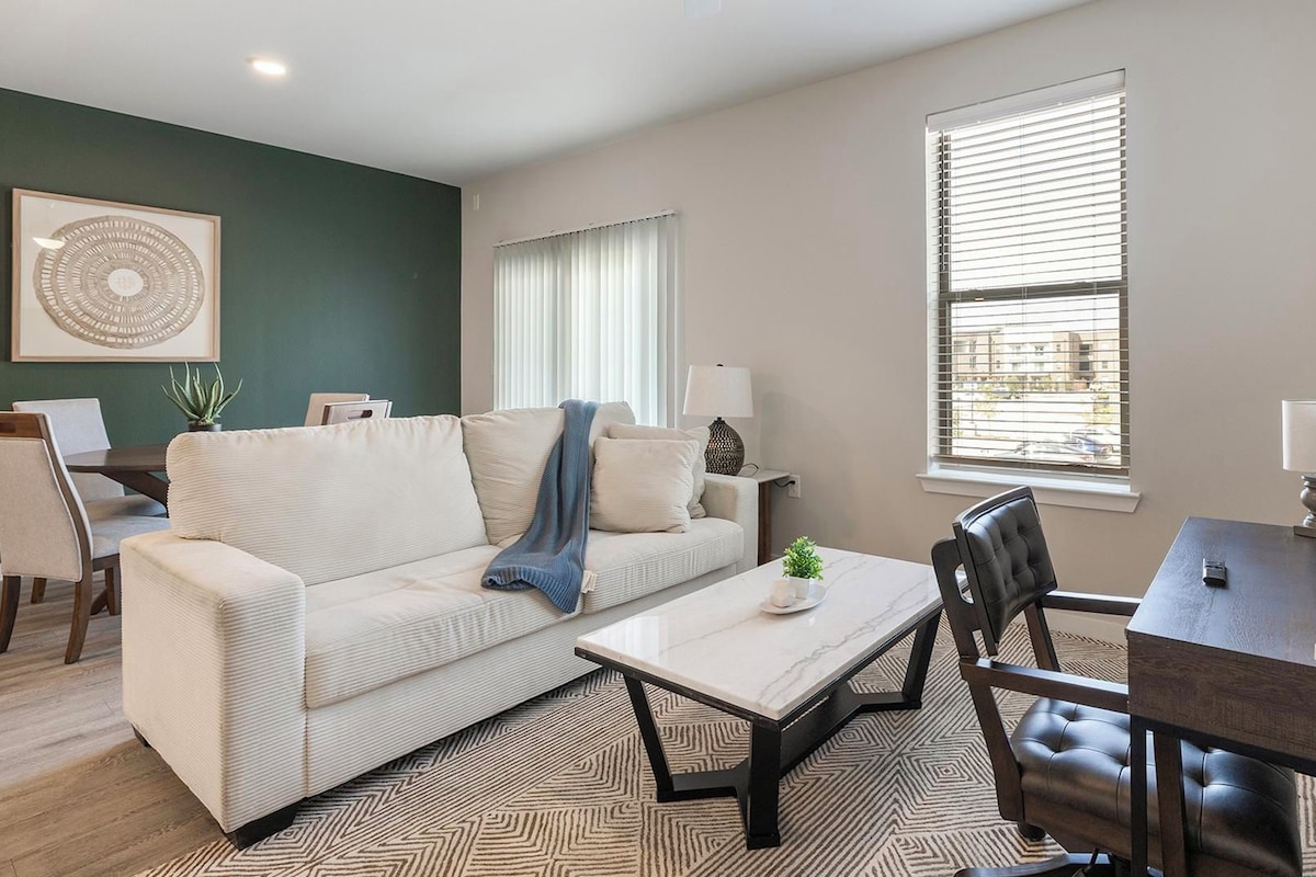 A living room with a sofa, coffee table, and dining area.
