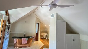 A room with a ceiling fan, a bathtub, and a white cabinet. - A Little Piece of Paradise – Cottage Point Waterfront Retreat (Cottage Point)