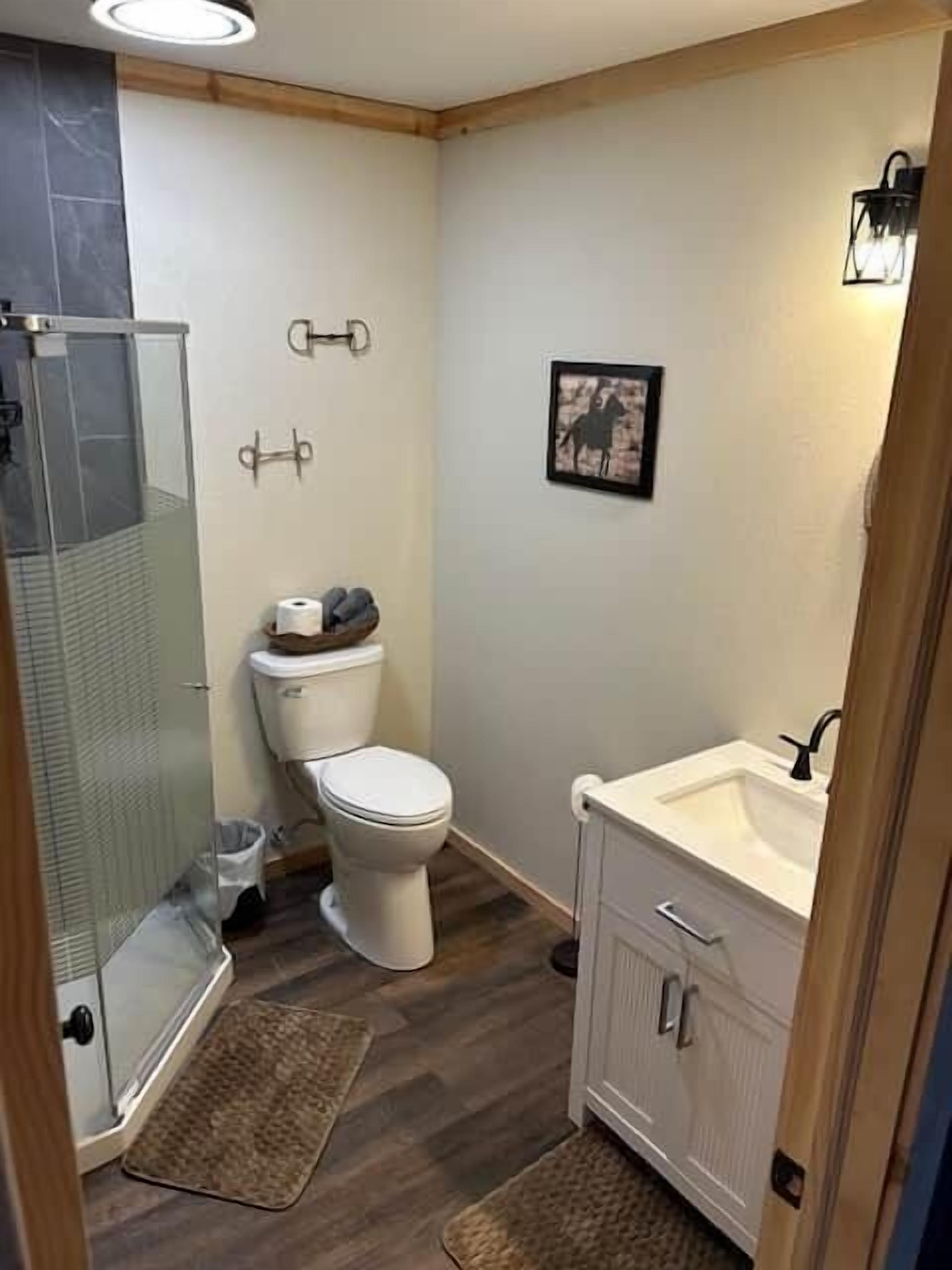 Un baño pequeño con inodoro, cabina de ducha y lavabo.