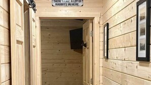 A wooden interior hallway with a sign stating "THERE'S LIKE, A LOT OF RABBITS IN HERE." - Jackrabbit on Plumb Ave (Tribune)