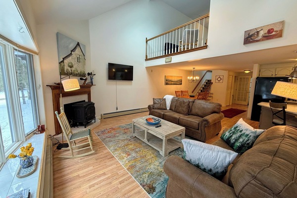 Main Level Living area sits adjacent to the dining and kitchen areas. This room offers lots of natural light, a gas stove and a smart TV.