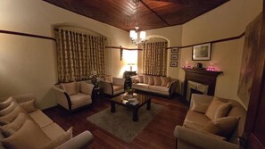 A cozy living room with two sofas, a coffee table, and a fireplace. - Brockenhurst Bungalow (Nuwara Eliya)