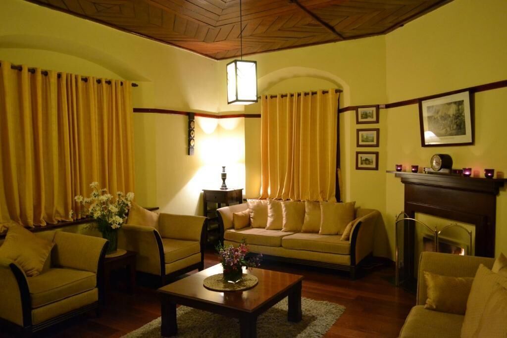 Una sala de estar acogedora con un sofá, sillones, una mesa de centro y una chimenea.