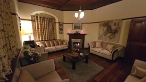 Ein gemütliches Wohnzimmer mit zwei Sofas, einem Kamin und einer Kristallleuchter.