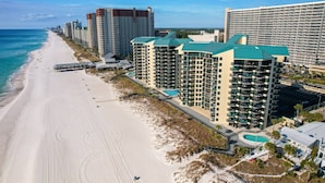 Un hotel sulla spiaggia con diversi edifici a grattacielo, una spiaggia sabbiosa e un cielo azzurro e limpido.