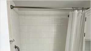 Ein Badezimmer mit Badewanne, Toilette und Duschvorhang.