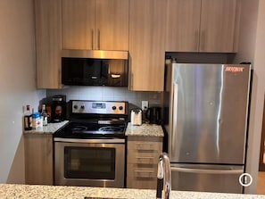 A kitchen with stainless steel appliances, including a stove, oven, microwave, and refrigerator. - Spacious-cozy 2bed Condo in Square Ones Misissauga (Mississauga)