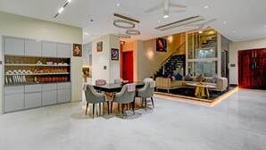 A modern interior with a dining area, a sofa set, and a staircase. - Villa Verizon by Dancenter (Hyderabad)
